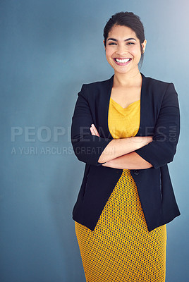 Buy stock photo Studio portrait of an attractive young businesswoman standing against a blue background