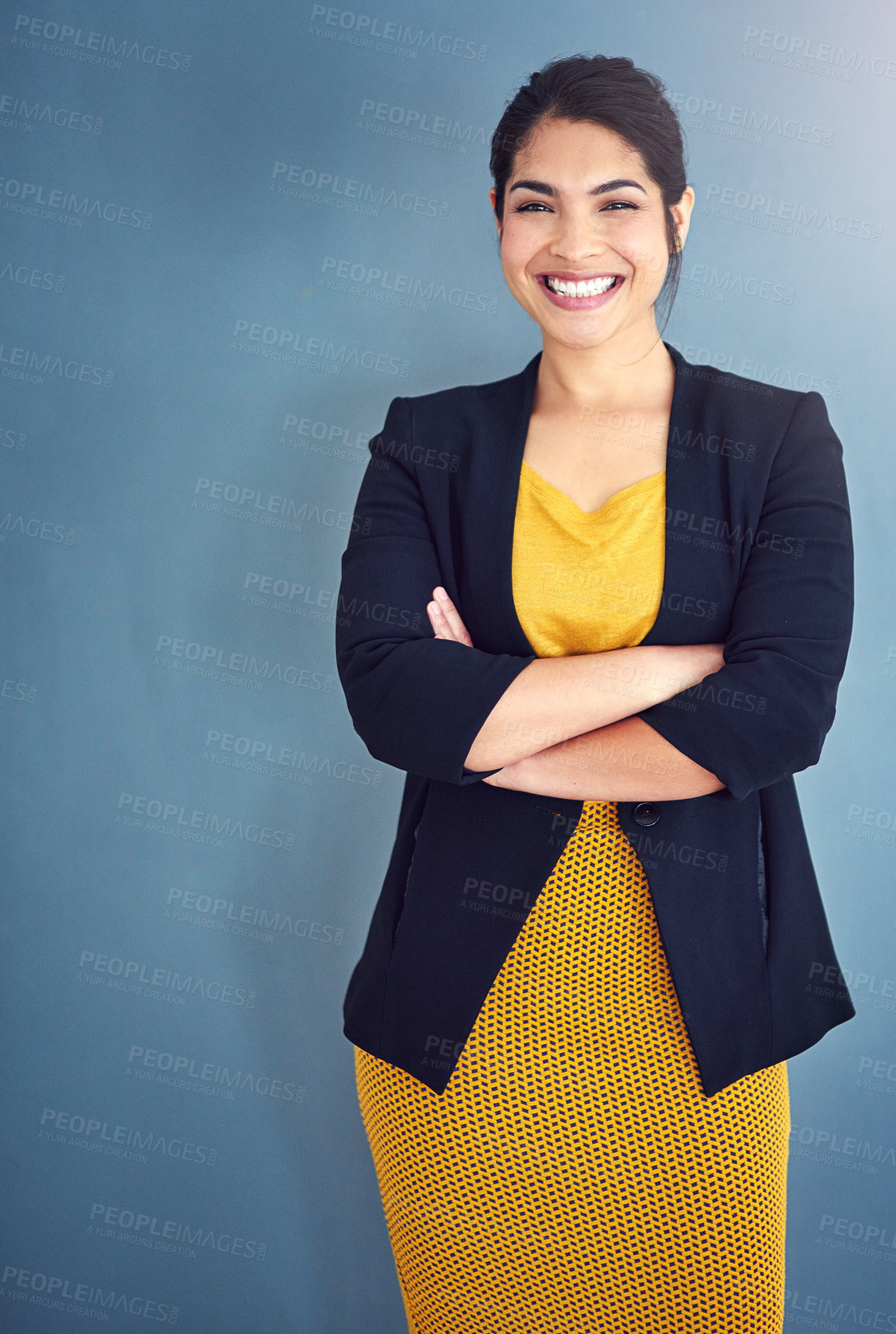 Buy stock photo Studio portrait of an attractive young businesswoman standing against a blue background