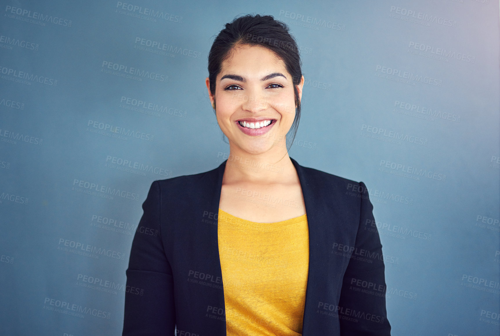 Buy stock photo Studio portrait of an attractive young businesswoman standing against a blue background