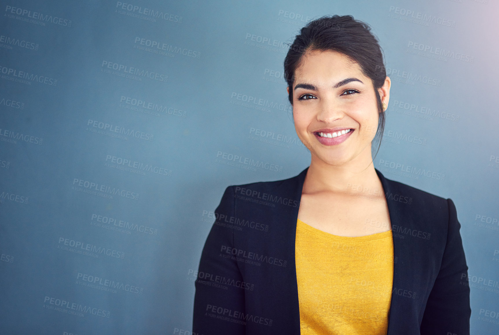 Buy stock photo Studio portrait of an attractive young businesswoman standing against a blue background