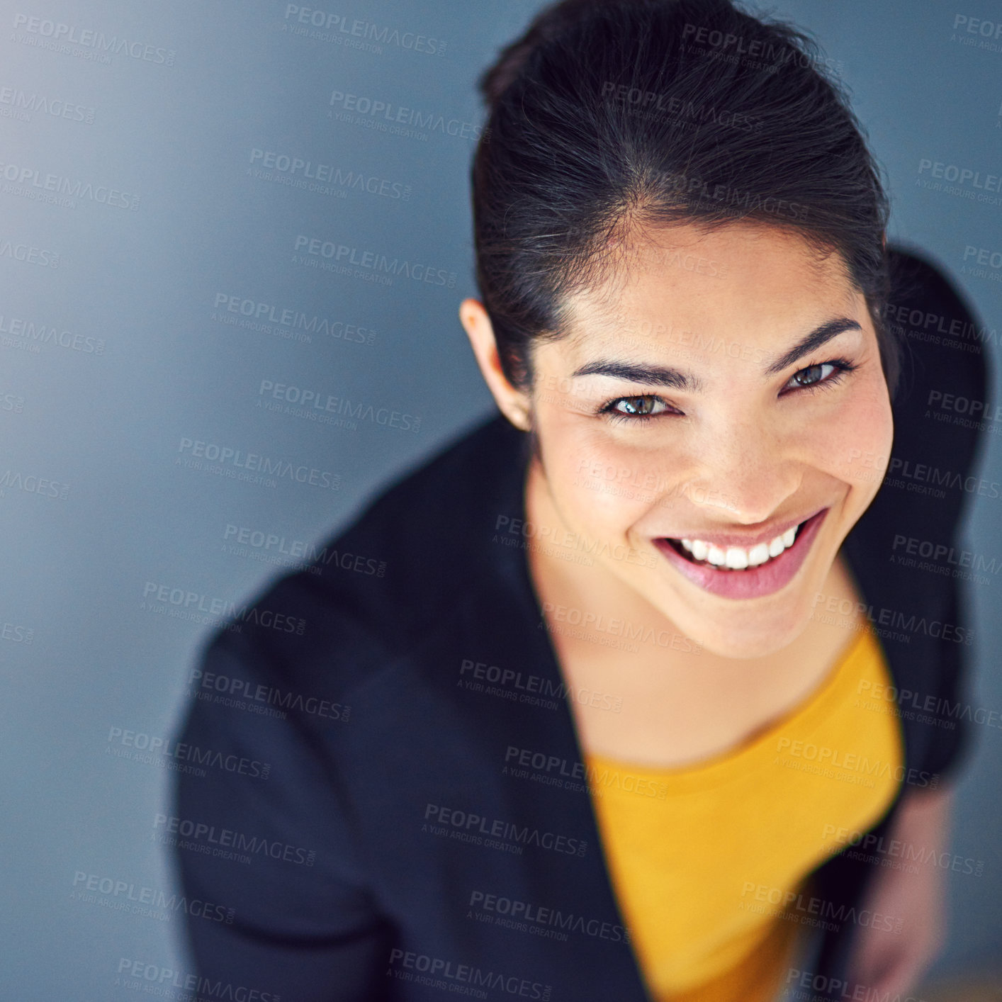 Buy stock photo Studio portrait of an attractive young businesswoman standing against a blue background