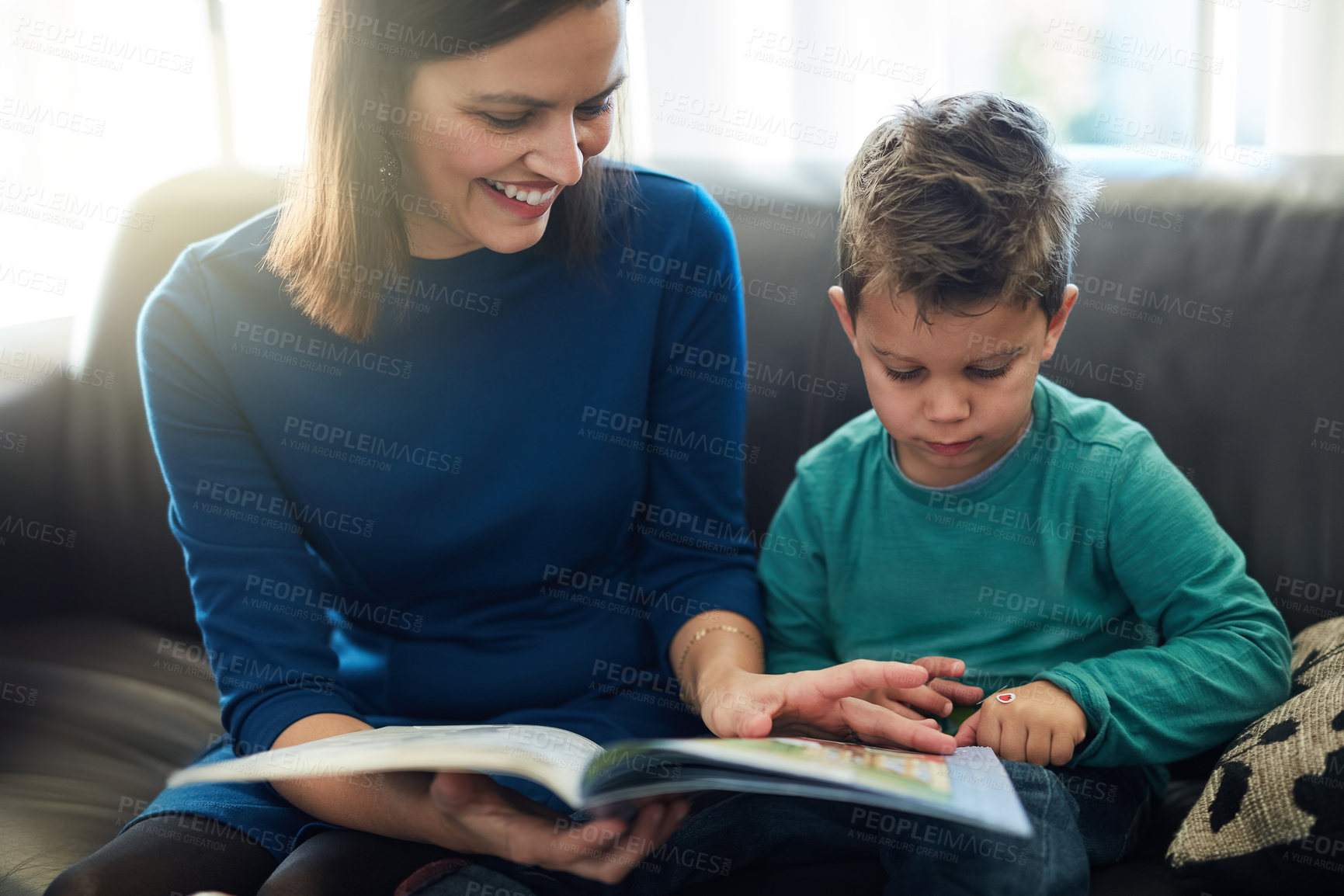 Buy stock photo Cropped shot of a mother reading a book to her little son at home