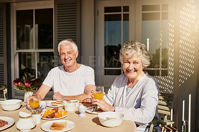 Buy stock photo Shot of a happy senior couple having a leisurely breakfast on the patio at home