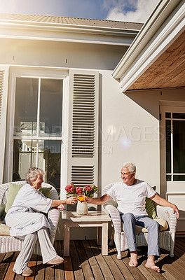 Buy stock photo Cheers, patio and senior couple with juice enjoying bonding, quality time and relax in morning. Love, retirement and happy elderly man and woman smile with drink for breakfast outdoors at home