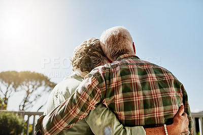 Buy stock photo Rearview shot of a senior couple embracing outside on the balcony