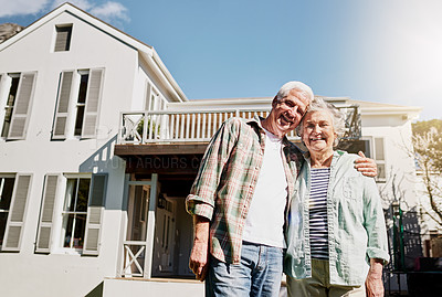 Buy stock photo Shot of a happy senior couple standing together in front of their house