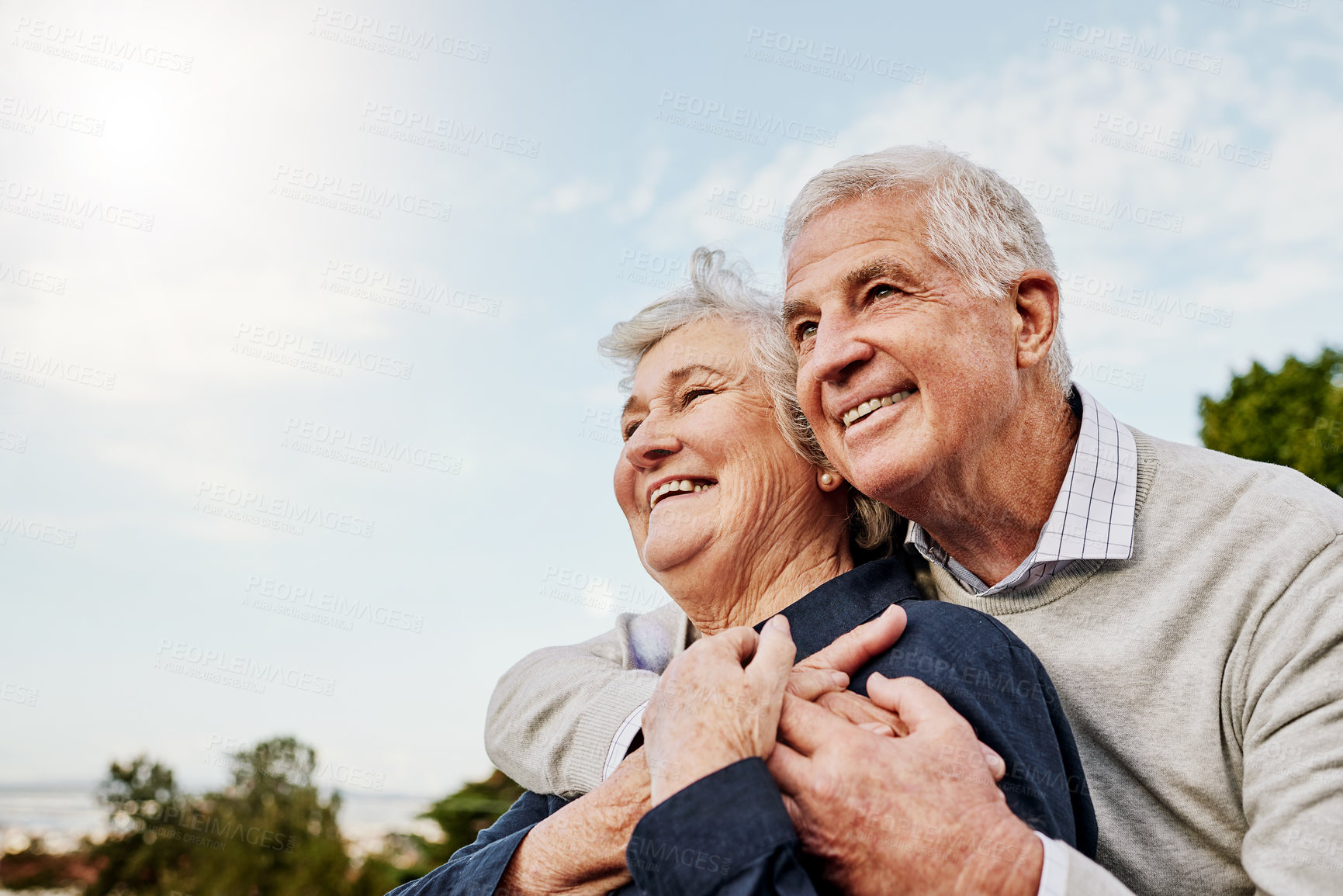 Buy stock photo Sky, elderly couple and hug outdoors or happy in retirement or husband and wife in nature. Mature, man and woman smile in vacation or senior citizens care and embrace or date at the park for romance