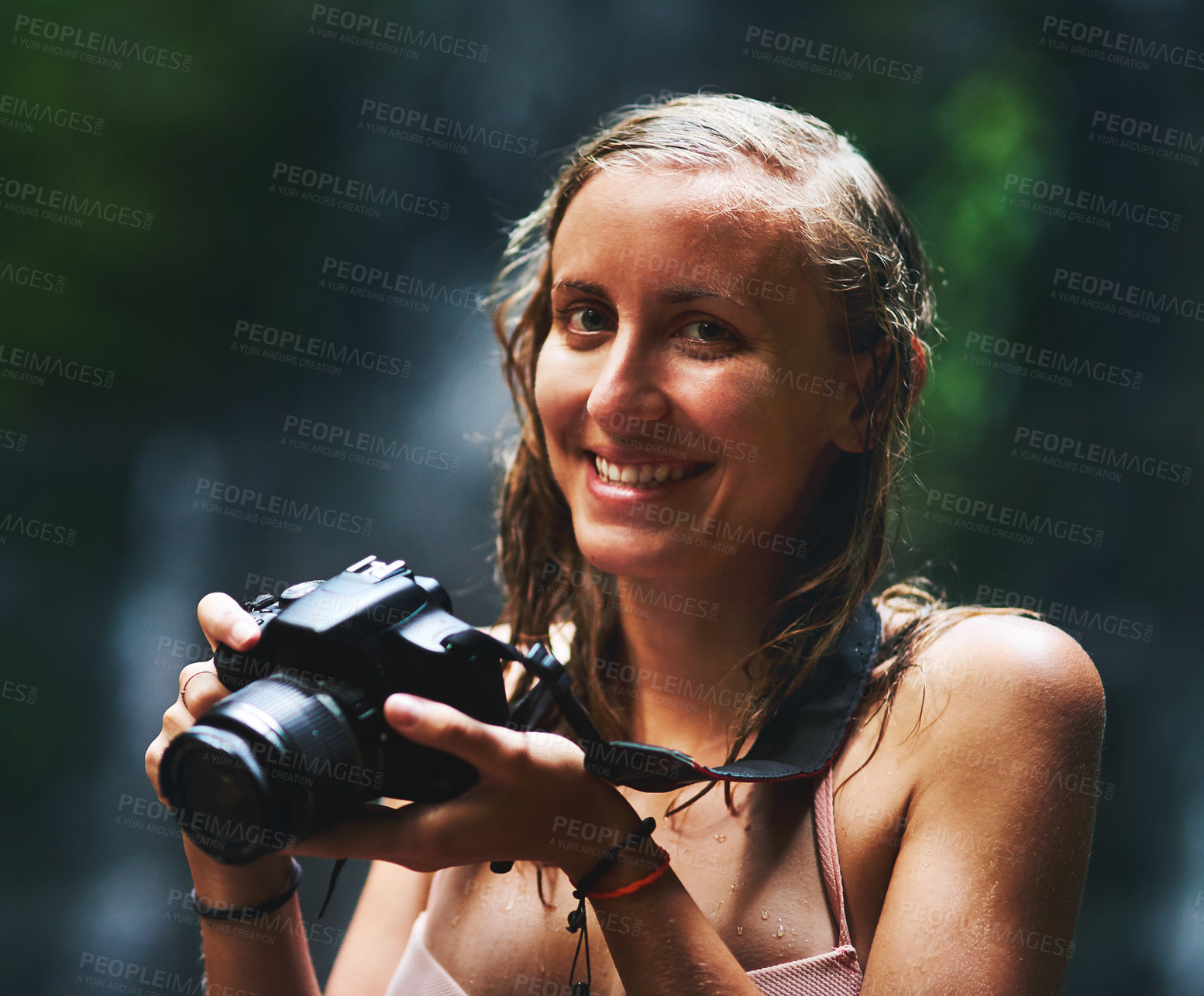 Buy stock photo Shot of a smiling young woman holding up a camera and looking happy as can be