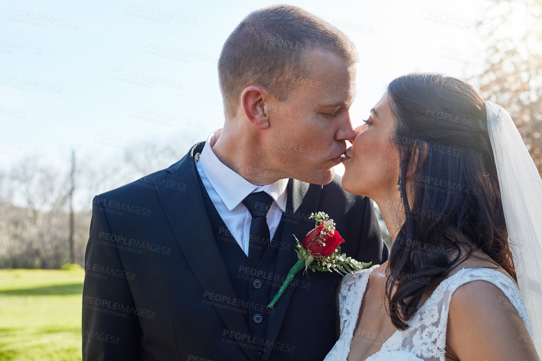 Buy stock photo Cropped shot of a bride and groom kissing on their wedding day