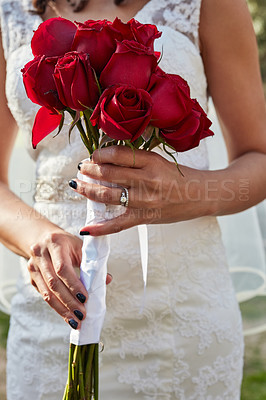 Buy stock photo Cropped shot of an unrecognisable bride holding a bouquet of red roses on her wedding day