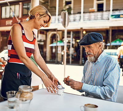 Buy stock photo Shot of a friendly waitress serving a senior man at a table outside a cafe