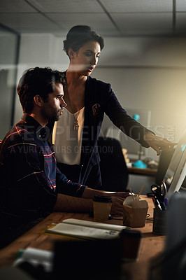 Buy stock photo Shot of two colleagues working late on a computer in an office