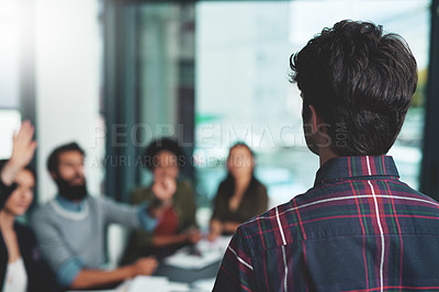 Buy stock photo Shot of a group of people raising their hands during a presentation in an office