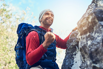 Buy stock photo Shot of a happy young hiker enjoying a mountain trail on his own