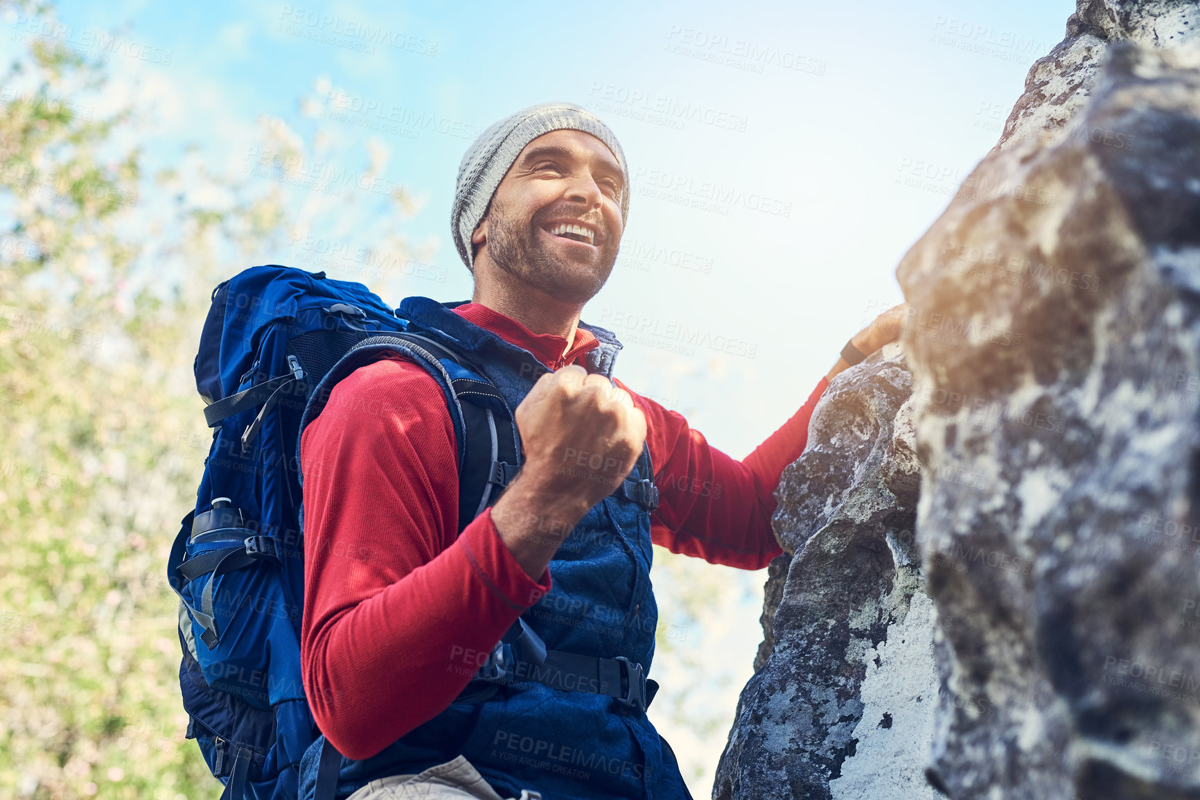 Buy stock photo Shot of a happy young hiker enjoying a mountain trail on his own