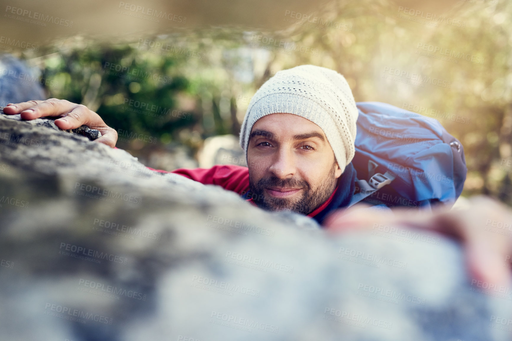 Buy stock photo Portrait of a happy hiker climbing over rocks on a mountain trail
