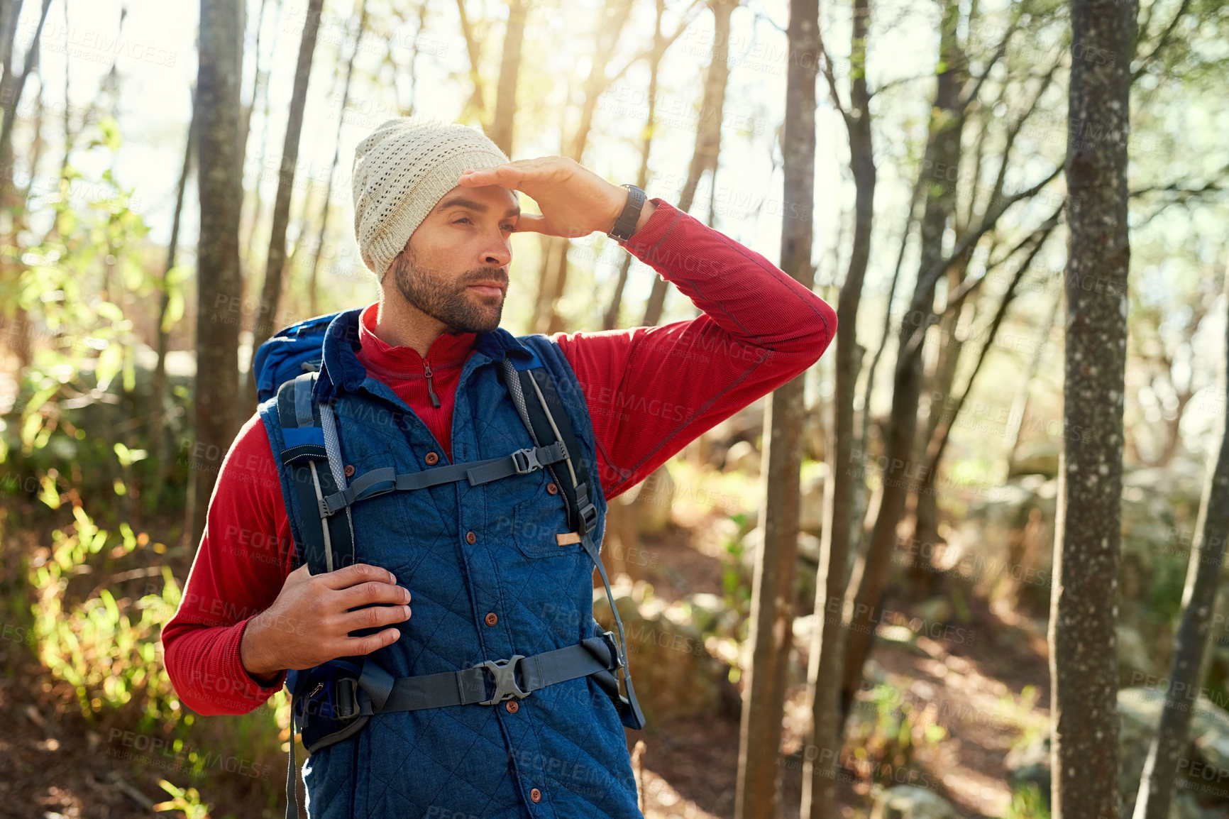 Buy stock photo Shot of a happy hiker out on a mountain hiking trail on his own