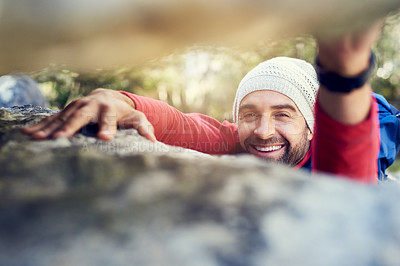 Buy stock photo Portrait of a happy hiker climbing over rocks on a mountain trail