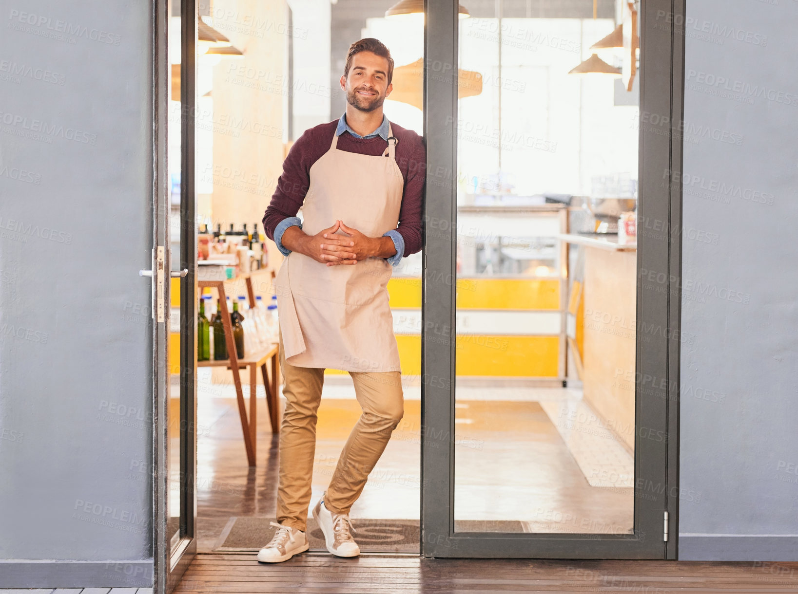 Buy stock photo Happy man, portrait and entrance with door at cafe for small business, welcome or startup. Creative male person, businessman or waiter with smile or apron and ready for service at indoor coffee shop