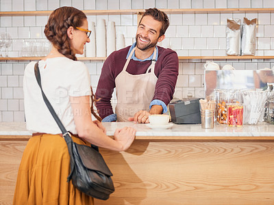 Buy stock photo Shot of a happy waiter serving a customer over the counter in a coffee shop