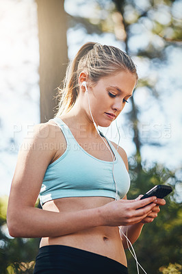 Buy stock photo Woman with earphones, smartphone and fitness with music outdoor, listening for motivation on run in park. Female runner with song choice, podcast or radio streaming with exercise, focus and health