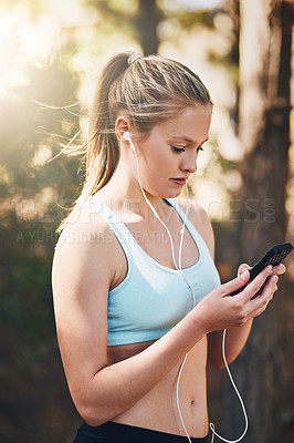 Buy stock photo Woman with earphones, phone and fitness with music outdoor, listening for motivation on run in park. Female runner with song choice on mobile, podcast or radio streaming for exercise and health