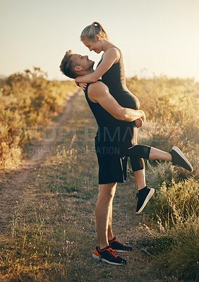 Buy stock photo Shot of a young man lifting his girlfriend outdoors