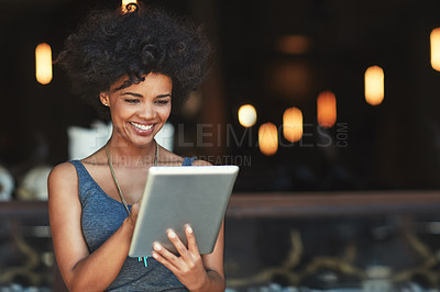 Buy stock photo Cropped shot of a young woman using a digital tablet in a cafe