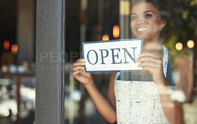 Buy stock photo Cropped shot of a young woman hanging up an open sign on the window of her cafe