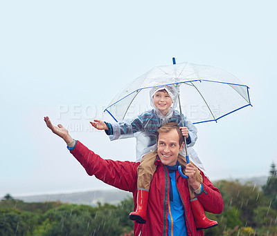 Buy stock photo Umbrella, father and child in rain for family fun, happiness and quality time. Happy man and boy kid outdoor in nature with hand to catch water drops for freedom, learning and play with sky mockup