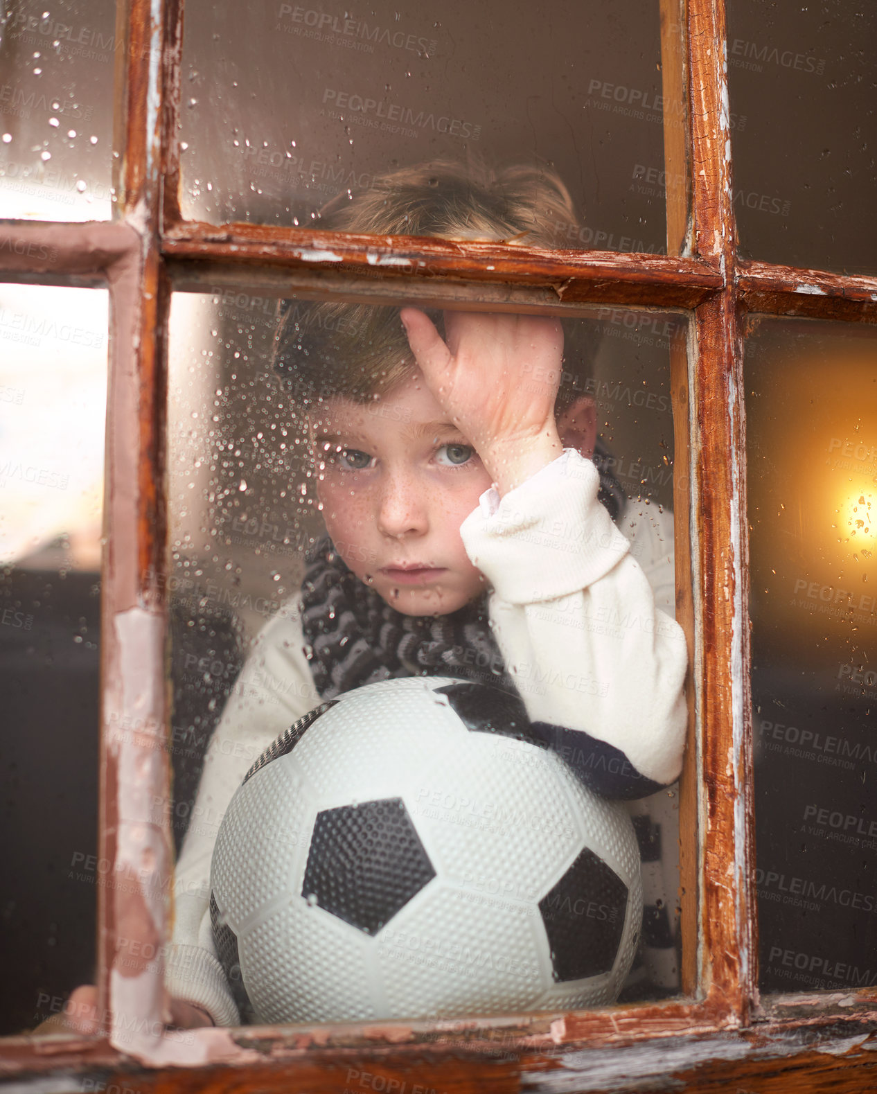 Buy stock photo Portrait, depressed and sad child by window with anxiety for bullying trauma, soccer ball and scared with stress. Orphan, football and young boy by glass for lonely and adoption conflict in Ireland