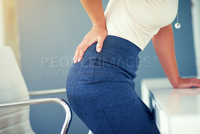 Buy stock photo Cropped shot of a young businesswoman holding her lower back in discomfort