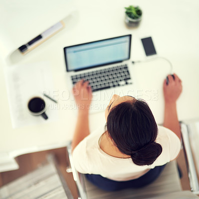 Buy stock photo High angle shot of a young businesswoman working on her laptop at home