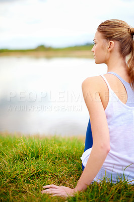 Buy stock photo Rearview shot of a young woman looking at a lake while doing yoga