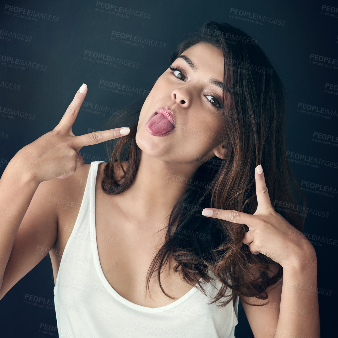 Buy stock photo Cropped shot of a beautiful young woman sticking out tongue against a grey background