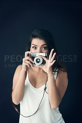 Buy stock photo Cropped shot of a beautiful young holding a camera against a dark background