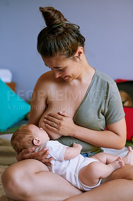 Buy stock photo Shot of a happy young mother breastfeeding her newborn baby at home