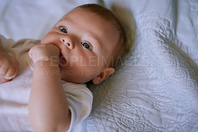 Buy stock photo Shot of an adorable baby boy lying down on a bed at home