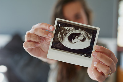Buy stock photo Shot of a woman holding a sonogram of her unborn baby