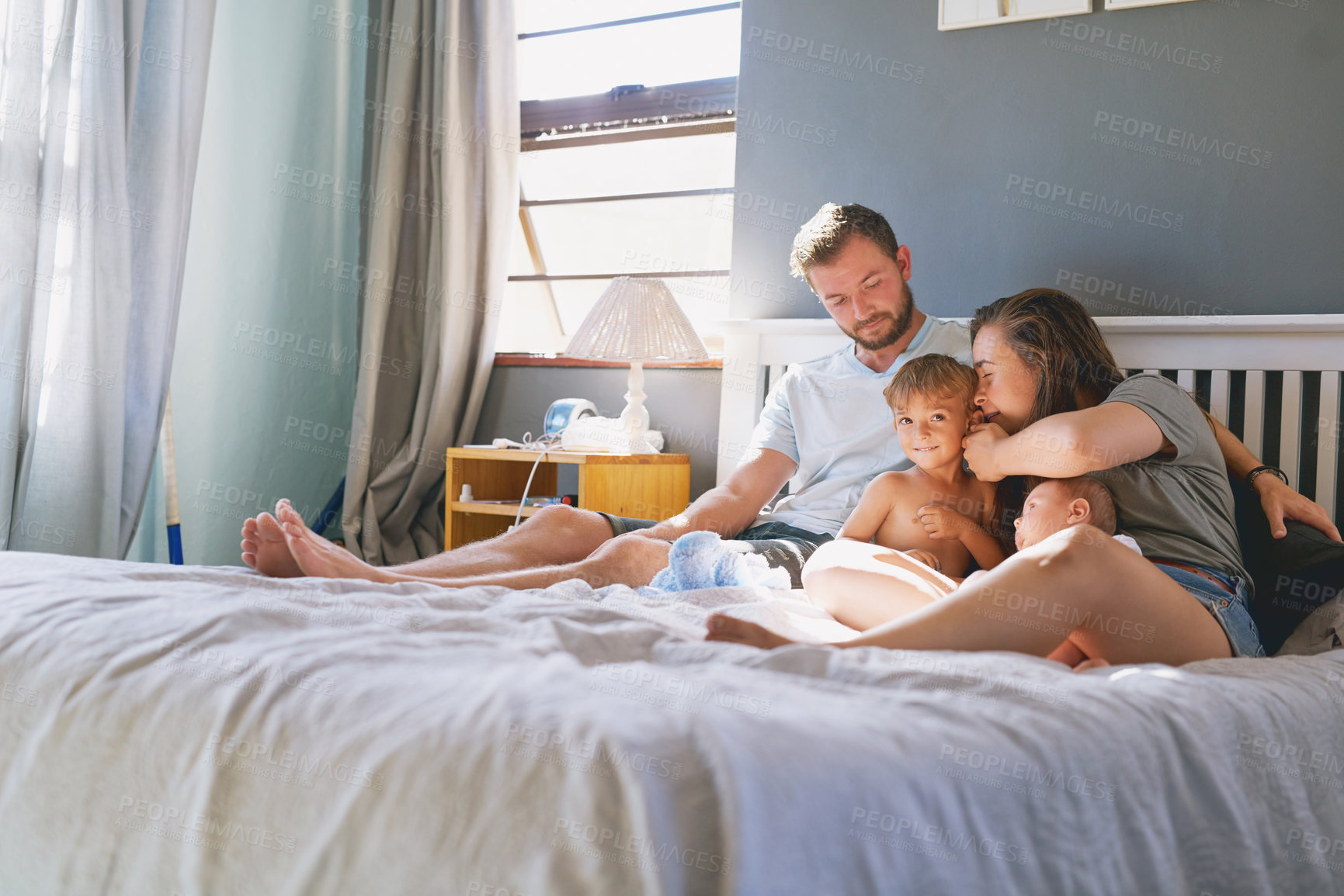 Buy stock photo Family, parents and children in bed of home, relax and weekend in bedroom. Cuddle, support and mother person with father for love and childhood development, kid and smile for care and happiness