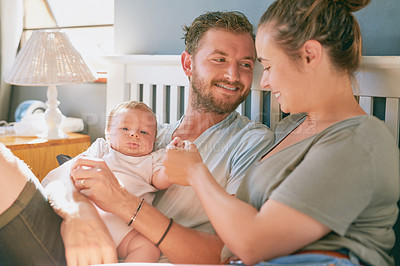 Buy stock photo Shot of a young mother and father bonding with their newborn baby boy in the bedroom