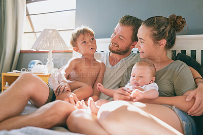Buy stock photo Shot of a young family of four bonding in the bedroom