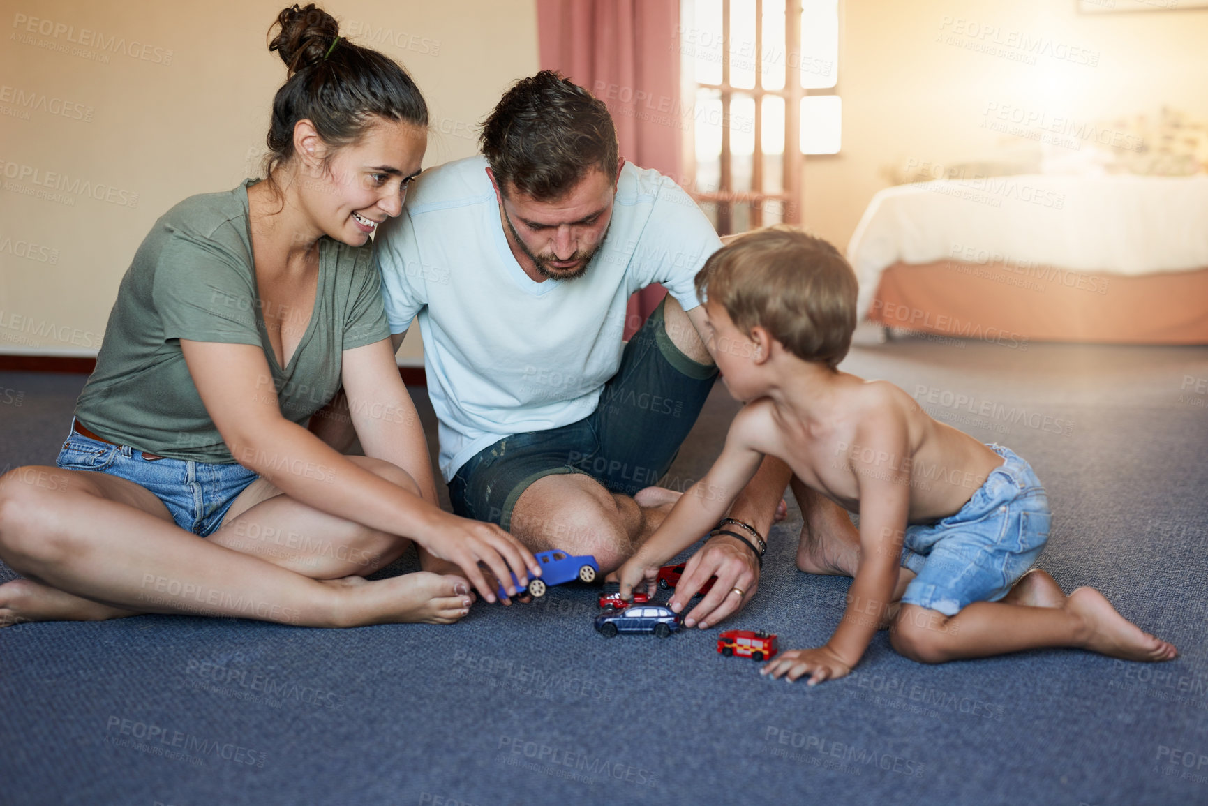 Buy stock photo Shot of a little boy and his father playing with toy cars at home