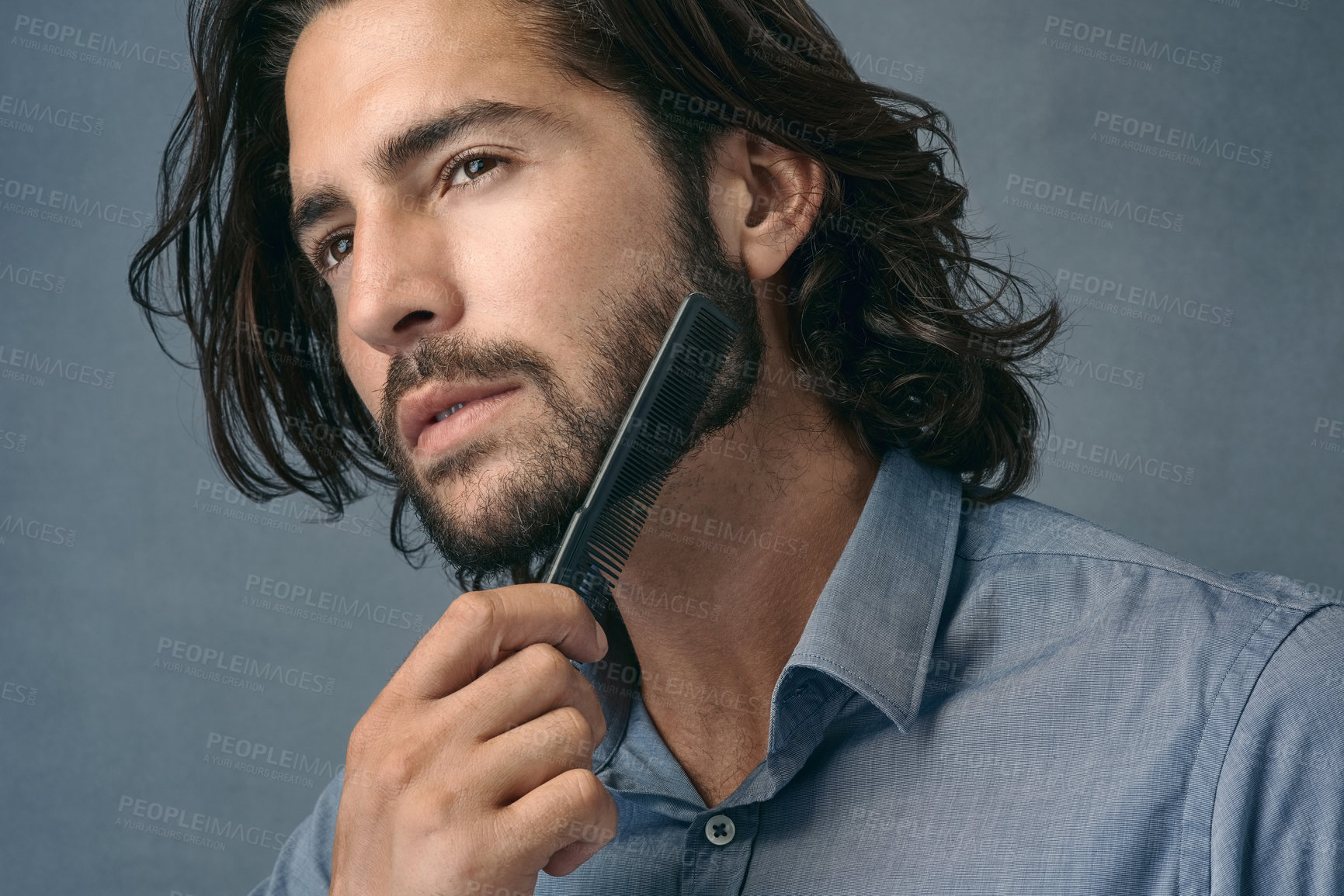 Buy stock photo Handsome man, thinking and haircare with comb for grooming, morning or routine on a gray studio background. Male person, employee or model with brush in wonder for beard or facial hair treatment