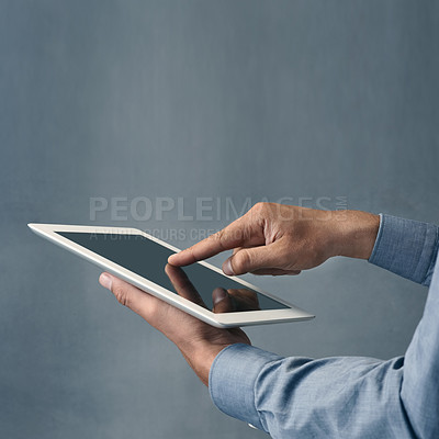 Buy stock photo Cropped shot of a man using a digital tablet against a grey background