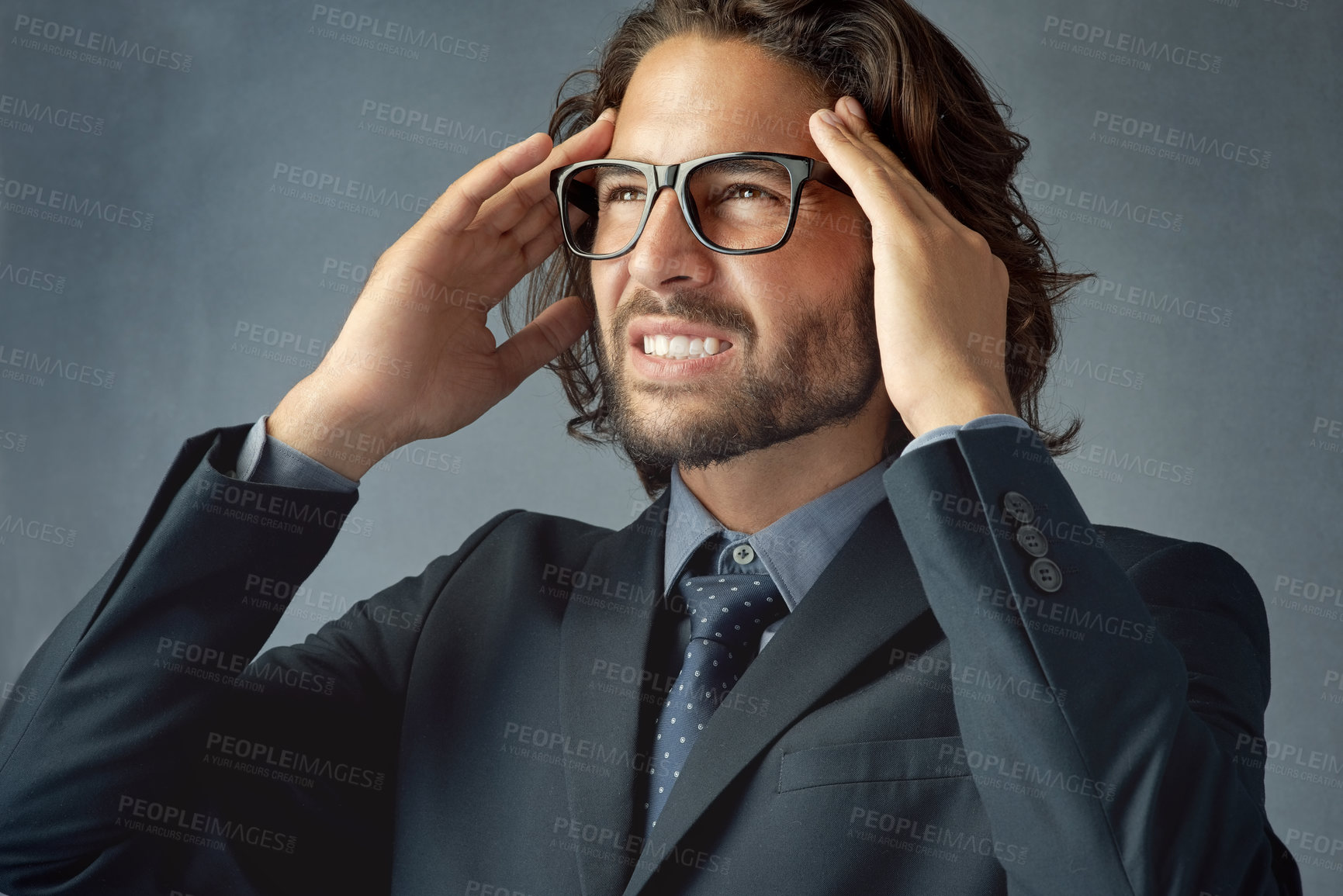 Buy stock photo Frustrated businessman, headache and stress with pain for difficult decision on a gray studio background. Young man or upset employee with migraine with mistake, pressure or strain for tough choice