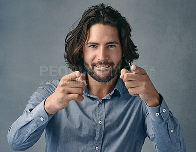 Buy stock photo Studio shot of a handsome young man pointing at the camera against a grey background