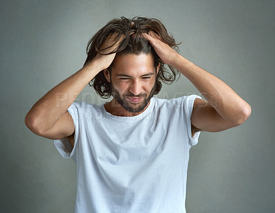 Buy stock photo Studio shot of a young man looking upset against a grey background