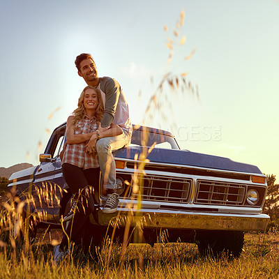 Buy stock photo Shot of an affectionate young couple enjoying a roadtrip together