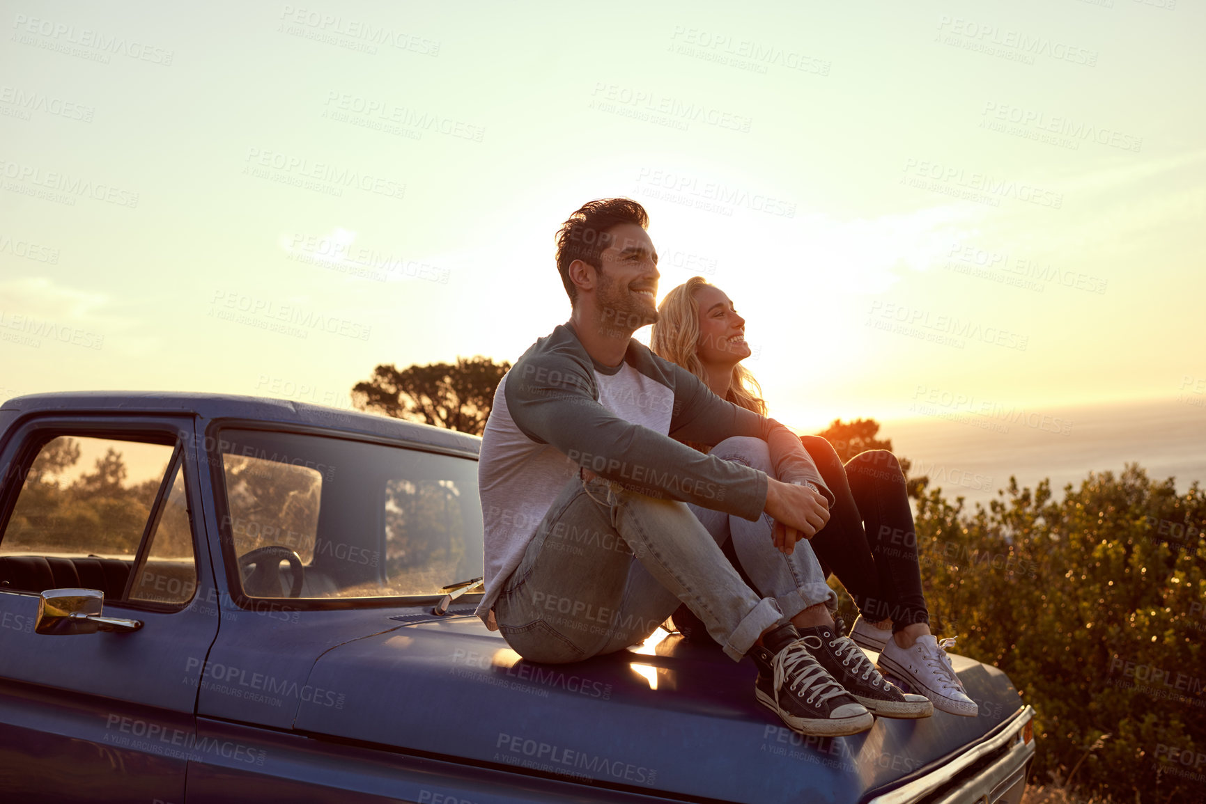 Buy stock photo Shot of a young couple admiring the view while enjoying a roadtrip together